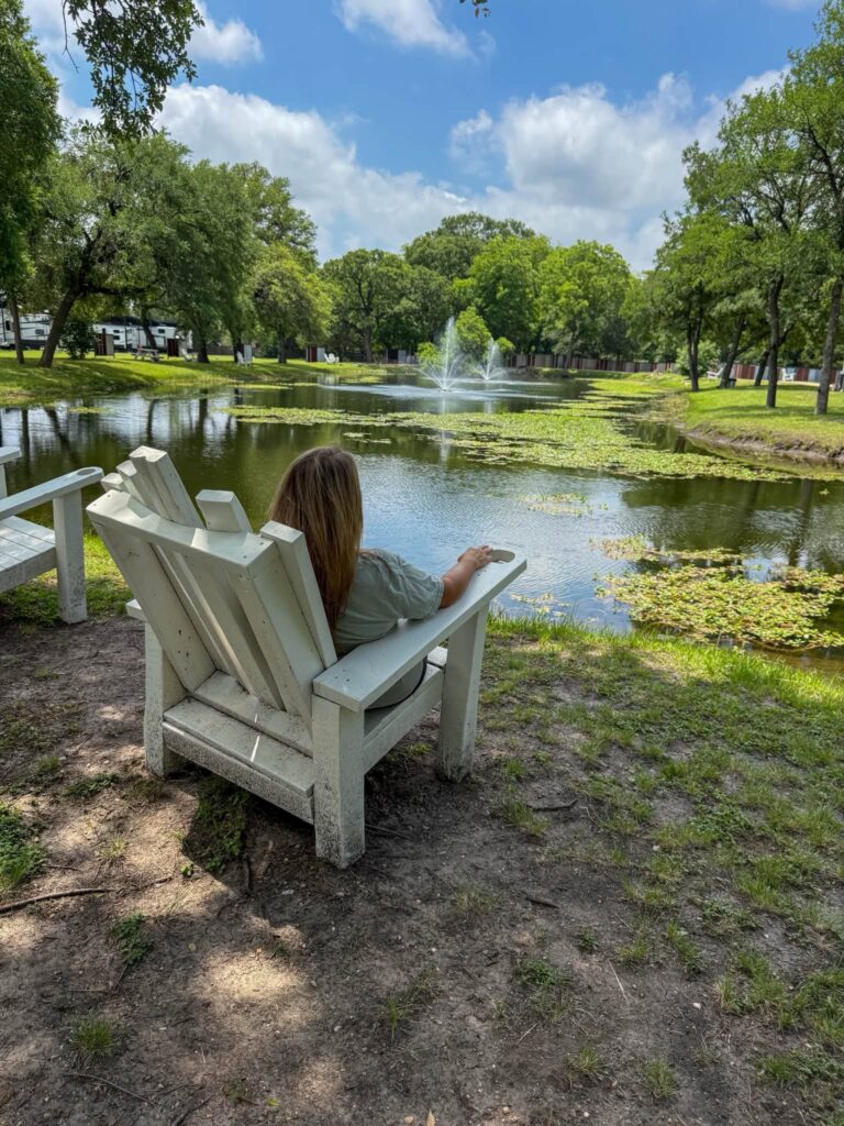 Adirondack chairs by the pond at Magnolia RV Resort in Waco