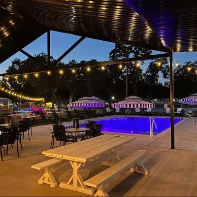 Pool and covered patio with string lights at Magnolia RV Resort