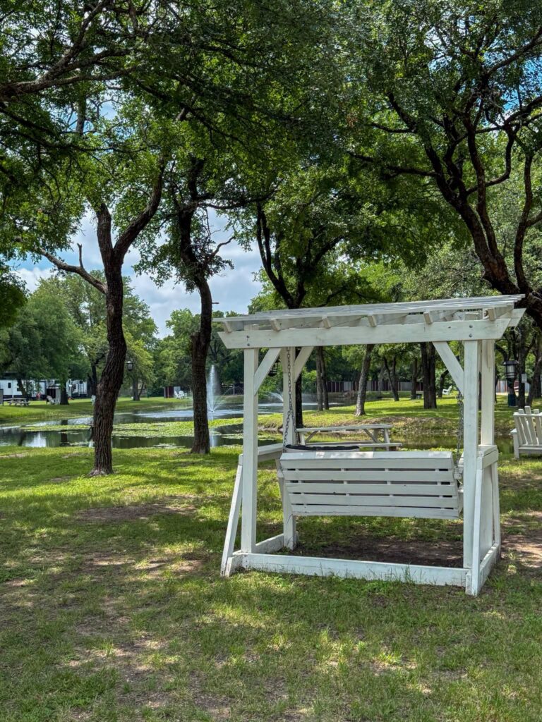 Porch swing under shade trees at Magnolia RV Resort